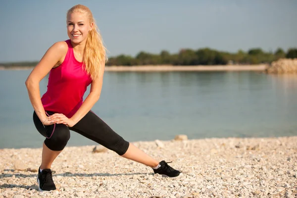 Trening - rano, rozciągający się na plaży, w pobliżu morza — Zdjęcie stockowe