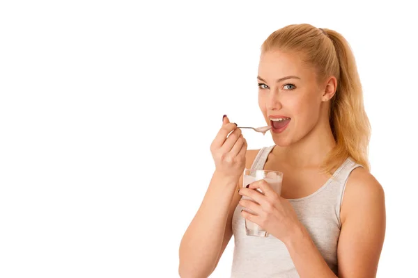 Linda mujer rubia comiendo yogur de frutas aislado sobre fondo blanco —  Fotos de Stock