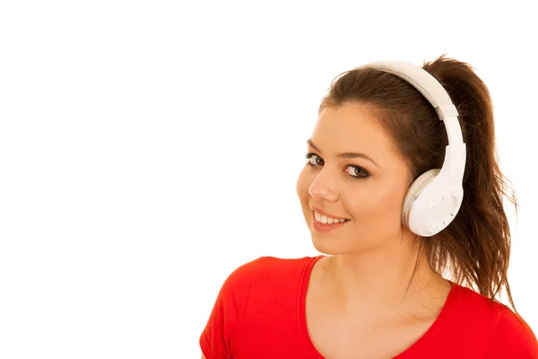 Mujer joven escucha música con auriculares aislados sobre respaldo blanco — Foto de Stock