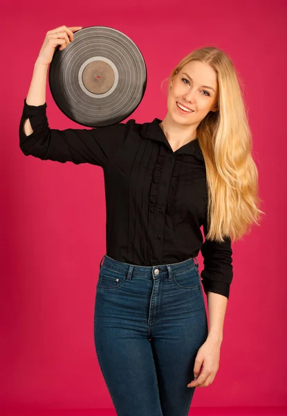 Vacker ung kvinna håller en vinyl i hennes händer som hon Lyssna — Stockfoto