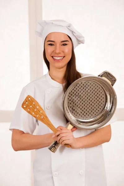 Asiático caucásico chef woamn sostiene utensilios de cocina como ella se prepara a coo —  Fotos de Stock