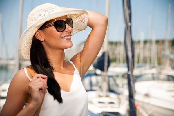 Giovane donna con cappello vestito estivo e occhiali da sole passeggiate molo di m — Foto Stock