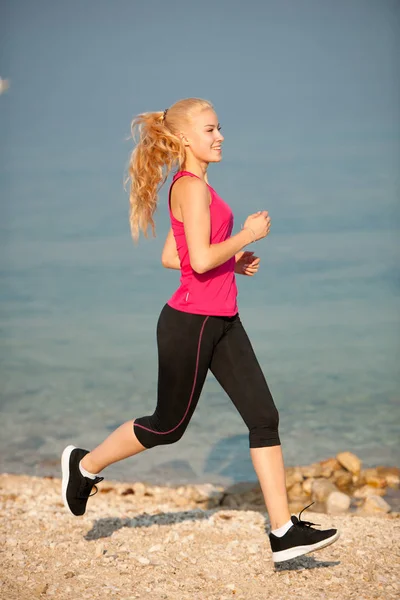 Jogging à la plage th - femme court près de la mer au début de l'été morni — Photo