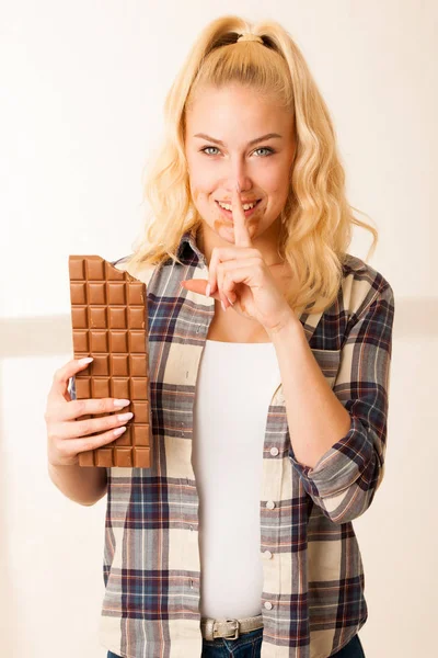 Όμορφη ξανθιά γυναίκα τρώει μια μεγάλη σοκολάτα — Φωτογραφία Αρχείου