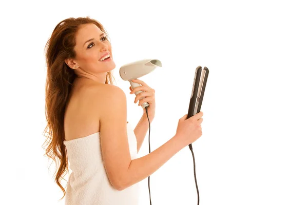 Hermosa mujer joven sostiene cepillo de pelo y secador de pelo aislado o —  Fotos de Stock