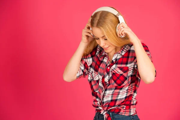 Νεαρή ξανθιά γυναίκα με ακουστικά ακούει τη μουσική πέρα από την pi — Φωτογραφία Αρχείου