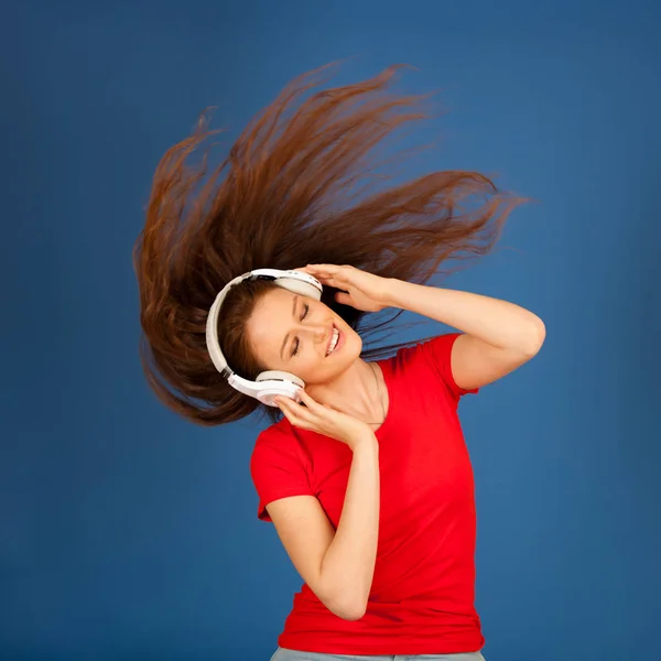 Mooie jonge vrouw luisteren naar de muziek en dans over levendige — Stockfoto