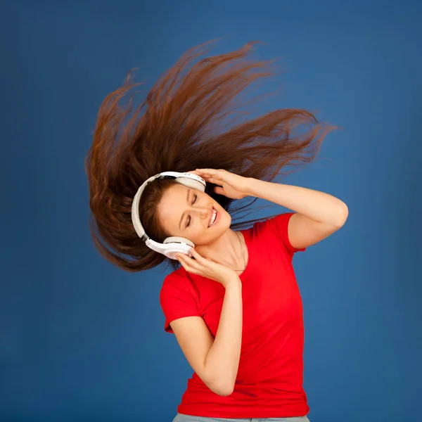 Beautiful young woman listen to the music and dance over vibrant — Stock Photo, Image