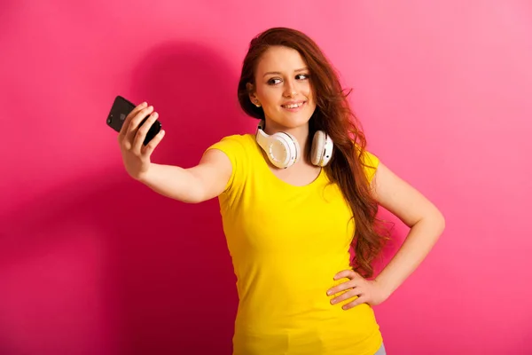 Donna scattare foto selfie su vibrante sfondo rosa — Foto Stock