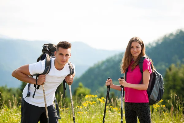 Ativo Bonito casal jovem caminhadas ina natureza escalada colina ou — Fotografia de Stock