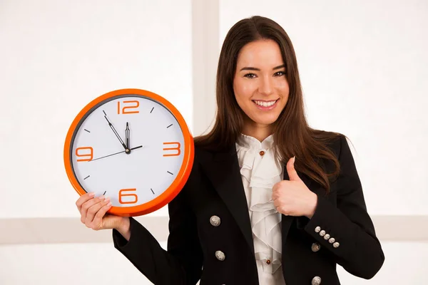 Mujer linda sosteniendo un reloj como símbolo de la gestión del tiempo —  Fotos de Stock