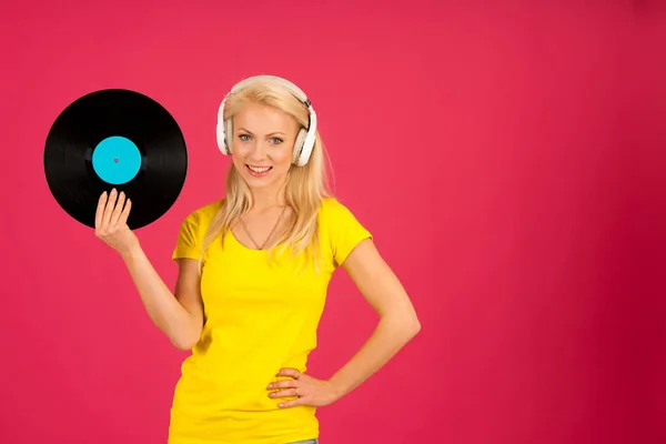 Güzel genç sarışın bir kadın canlı renk b üzerinden müzik dinleme — Stok fotoğraf