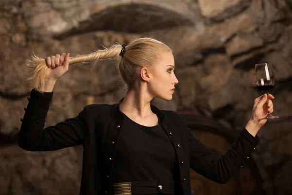 Belle jeune femme blonde boit du vin dans une cave à vin — Photo