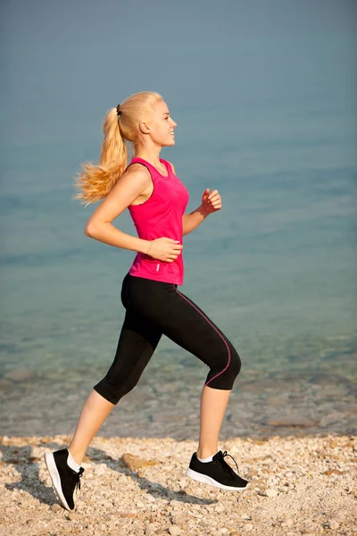 Joggen in th strand - vrouw runns in de buurt van de zee op vroege zomer morni — Stockfoto