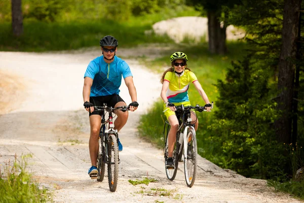 ACTIVE Young couple biking on a forest road in mountain on a spr — Stock Photo, Image