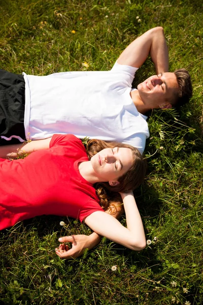 Active couple rests on a mountain peak looking on a mountain lan — Stock Photo, Image