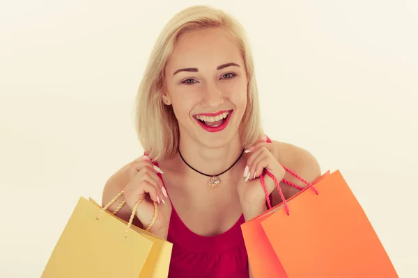 Aantrekkelijke blonde jonge vrouw met boodschappentassen geïsoleerd — Stockfoto