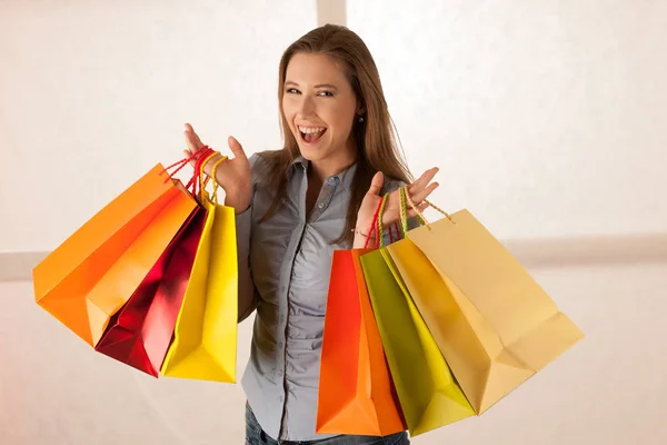 Aantrekkelijke jonge vrouw met boodschappentassen na aankoop in ma — Stockfoto