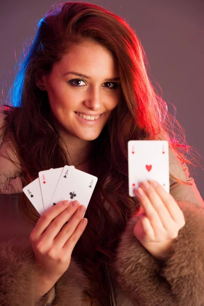 Beautiful brunette holding four aces as a sign for poker game, g — Stock Photo, Image