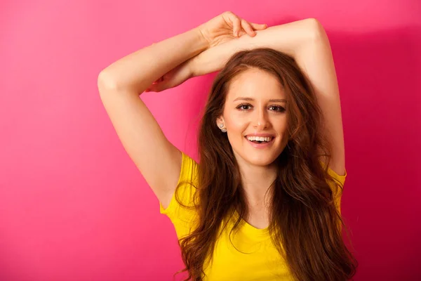 ピンクの上の黄色 t シャツ ダンスの美しい若い女性 — ストック写真