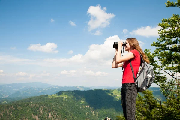 Active Young woman looking a mountain landscape with Binoculars — Stock Photo, Image