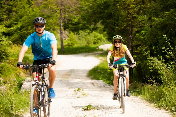 ACTIVE Young couple biking on a forest road in mountain on a spr — Stock Photo, Image