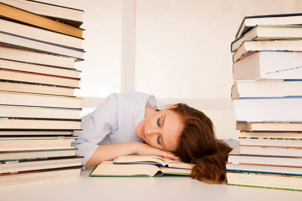 Attractive beautiful tired student sleeps on pile of books — Stock Photo, Image