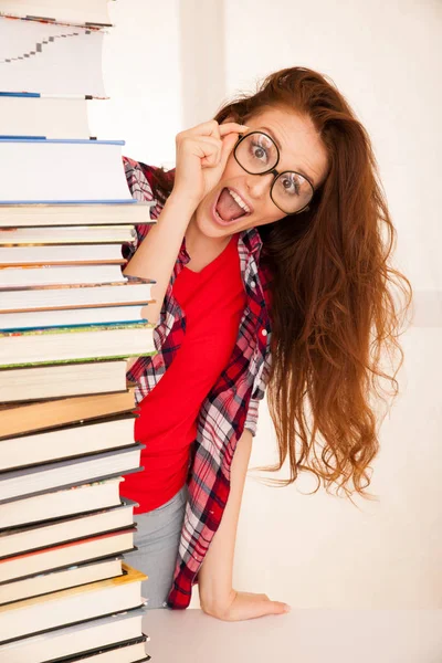 Attractive beautiful woman geek in study with pile of books — Stock Photo, Image