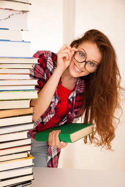 Attraktiva vacker kvinna geek i studie med högen av böcker — Stockfoto