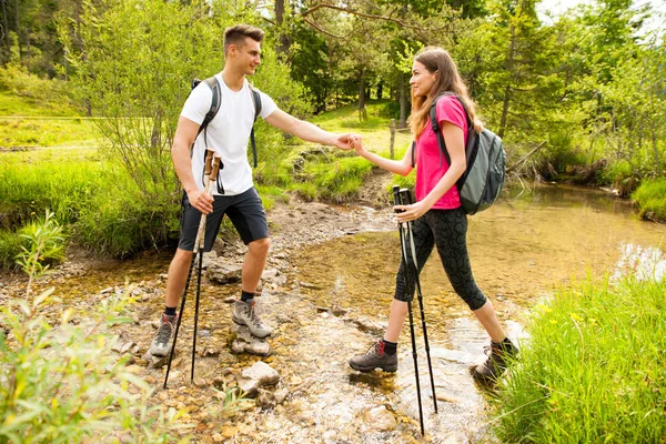 Ativo Bonito casal jovem caminhadas ina natureza escalada colina ou — Fotografia de Stock