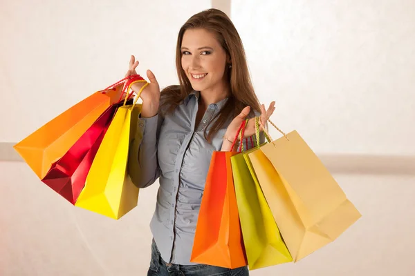 Aantrekkelijke jonge vrouw met boodschappentassen na aankoop in ma — Stockfoto