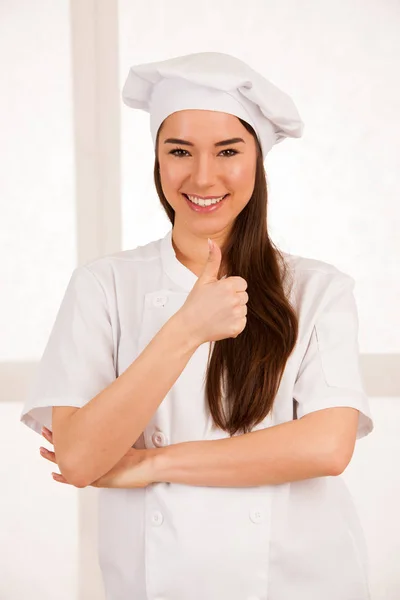 Jovem loira chef woamn detém utensílios de cozinha como ela se prepara para coo — Fotografia de Stock