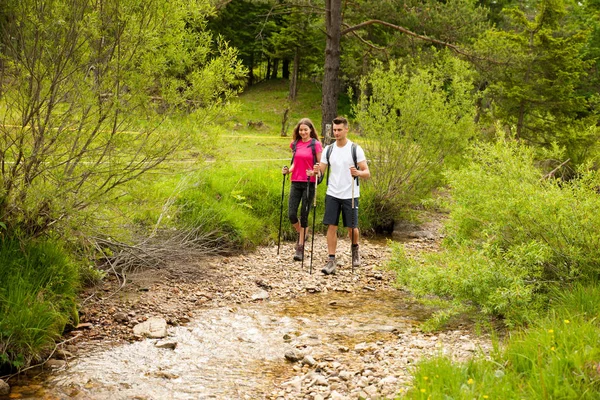 Ativo Bonito casal jovem caminhadas ina natureza escalada colina ou — Fotografia de Stock