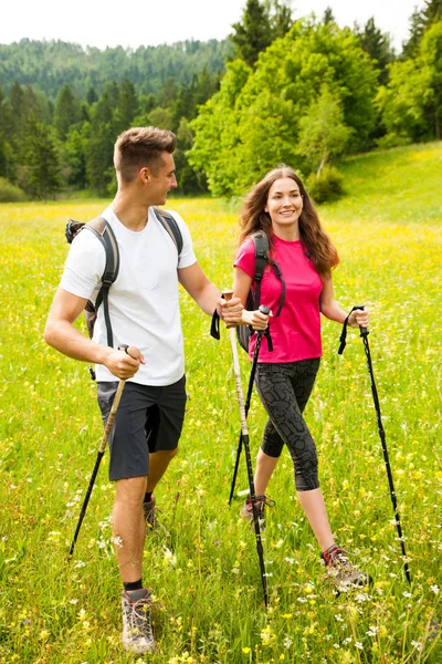 Active Beautiful young couple hiking ina nature climbing hill or — Stock Photo, Image