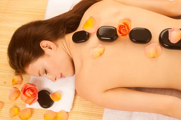 Terapia della pietra. Donna ottenere un massaggio di pietra calda al salone spa — Foto Stock