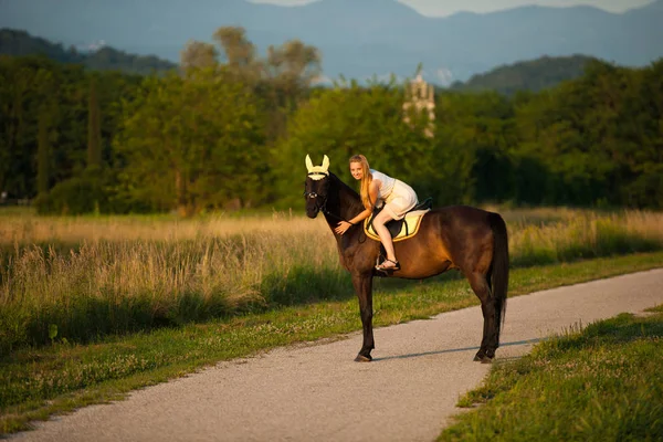 Jovem mulher ativa montar um cavalo na natureza — Fotografia de Stock