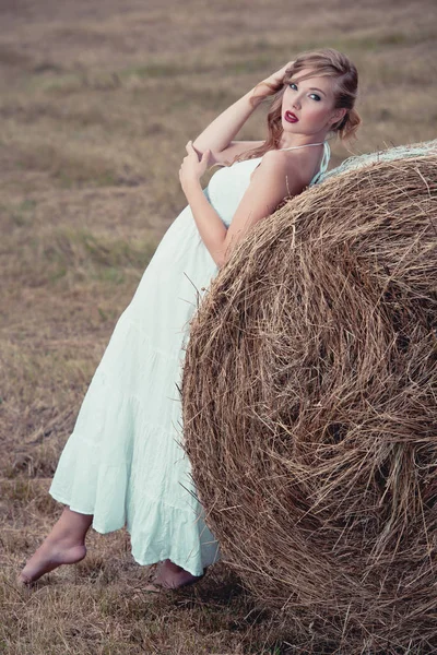 魅力的なスタイリッシュな女性は近くの長い白い夏服で干し草のバル — ストック写真