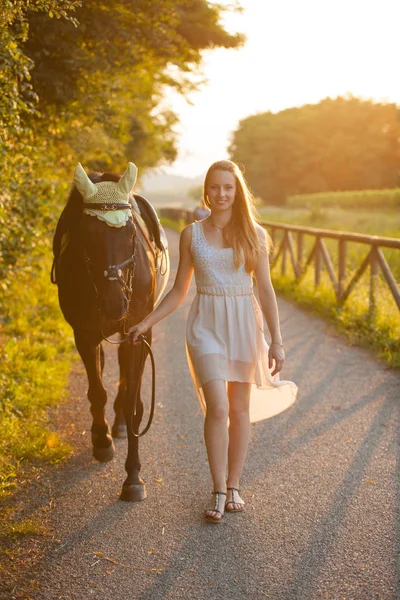 Mulher bonita com cavalo ao ar livre em um passeio na natureza — Fotografia de Stock