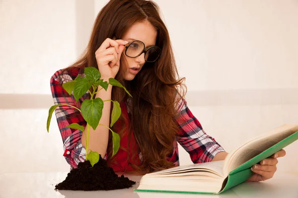 Çekici genç botanik öğrenci seedlnng ve kitaplar — Stok fotoğraf
