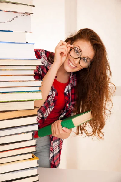 Aantrekkelijke mooie vrouw geek in studie met stapel boeken — Stockfoto