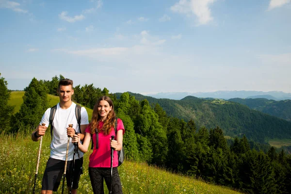 Ativo Bonito casal jovem caminhadas ina natureza escalada colina ou — Fotografia de Stock