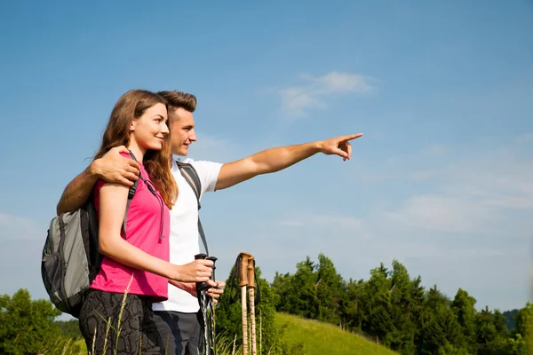 Aktiva vackert ungt par vandring ina natur klättring hill eller — Stockfoto