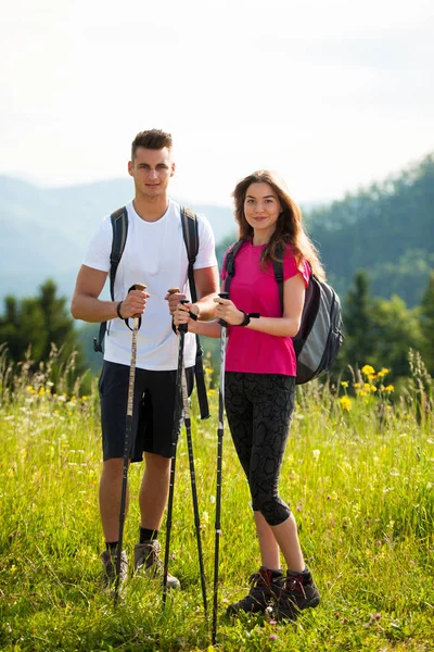 Aktiva vackert ungt par vandring ina natur klättring hill eller — Stockfoto