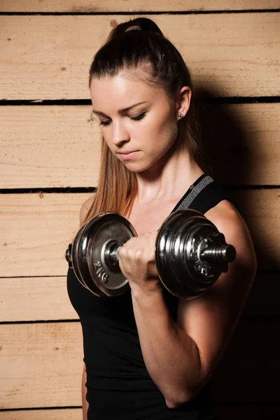 Mujer joven activa hacer ejercicio con pesas en gimnasio de fitness —  Fotos de Stock