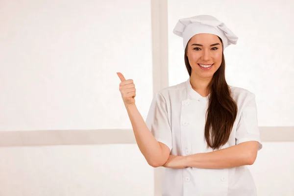 Jovem loira chef woamn detém utensílios de cozinha como ela se prepara para coo — Fotografia de Stock