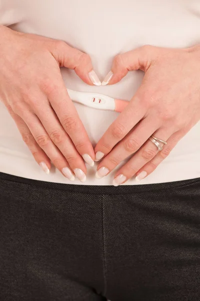 Tester ciąży na brzuch kobiety na białym tle nad biały backgrou — Zdjęcie stockowe