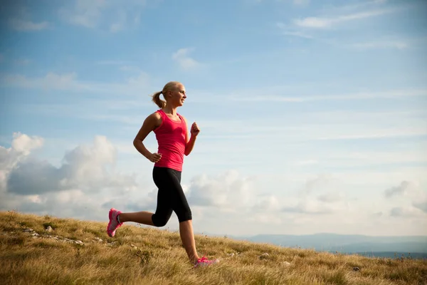 Corridore - donna corre attraverso il paese su un percorso all'inizio dell'autunno — Foto Stock