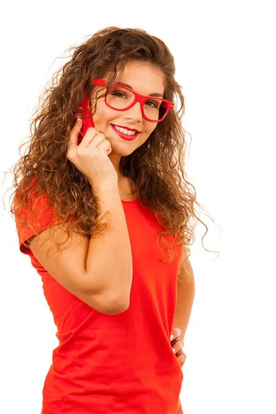 Hermosa joven en rojo hablando en un teléfono inteligente aislado o — Foto de Stock