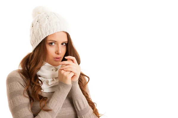 Beautiful young woman in sweater, hat and scarf gestures cold te Stock Photo