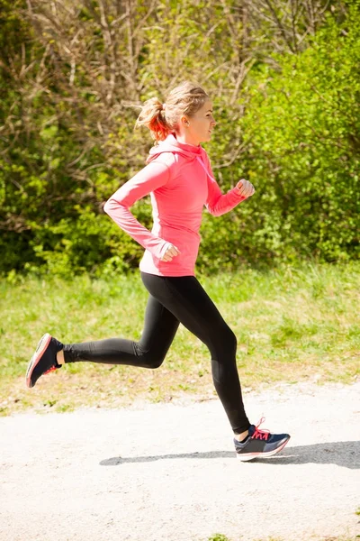 Jovem mulher de vestido rosa e preto corre cross country em um quente — Fotografia de Stock